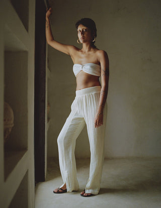 Elevate your holiday wardrobe with Anaak's Imane Pants. This piece of clothing comes in a natural shape of white and it's made from pure cotton, featuring a high-rise and an elasticated waistband. What differentiates Anaak's garments stands out from the rest because they are contemporary, but ancient textile processes are still used to make them. The design is airy for effortless and comfortable vacation wear.