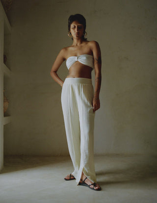 Elevate your holiday wardrobe with Anaak's Imane Pants. This piece of clothing comes in a natural shape of white and it's made from pure cotton, featuring a high-rise and an elasticated waistband. What differentiates Anaak's garments stands out from the rest because they are contemporary, but ancient textile processes are still used to make them. The design is airy for effortless and comfortable vacation wear.