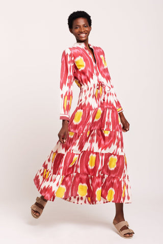 An instant hit, this Strawberry Pole-Pole from Kleed, ushering in the warm summer days and tropical evenings. A supremely flattering combination of berry crush and peachy pink, with irresistible sherbet yellow accents. We love the light single IKAT fabric, tapered line, elegant Mandarin collar, gathered sleeves buttoned at the cuff and gently flaring, four-tier flounces.