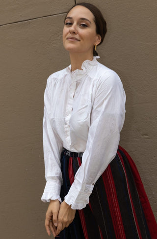 A classic piece of clothing that cannot be missing from your wardrobe. This silk blouse belongs to Injiri's Fall Winter 22 collection and comes in a white colour, has long sleeves and a unique ruffled collar. 