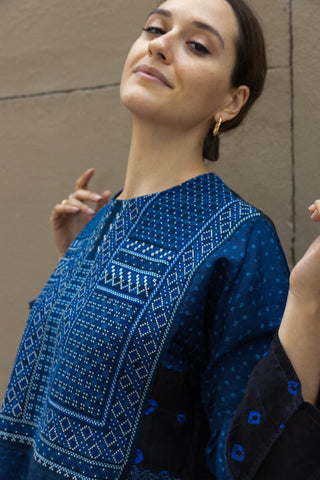 Fall in love with Injiri's dresses! Completely handmade, this midi model comes in an indigo blue shade with white hand-embroideries and it features long wide sleeves. Pleats at the waist provide more volume at the bottom.