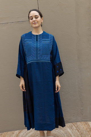 Fall in love with Injiri's dresses! Completely handmade, this midi model comes in an indigo blue shade with white hand-embroideries and it features long wide sleeves. Pleats at the waist provide more volume at the bottom.