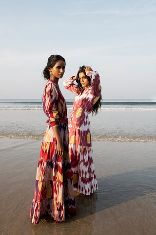 An instant hit, this Strawberry Pole-Pole from Kleed, ushering in the warm summer days and tropical evenings. A supremely flattering combination of berry crush and peachy pink, with irresistible sherbet yellow accents. We love the light single IKAT fabric, tapered line, elegant Mandarin collar, gathered sleeves buttoned at the cuff and gently flaring, four-tier flounces.