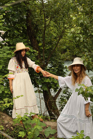  This absolute stunning bohemian dress from Santa Lupita is a safe bet to get full of compliments Summer after Summer. Its long and airy wide-cut skirt swings all around you and invites you to dance and sense the freedom. The multi-layered cuffs and the multicolored embroideries radiate joy and reminds us of blooming flowers.